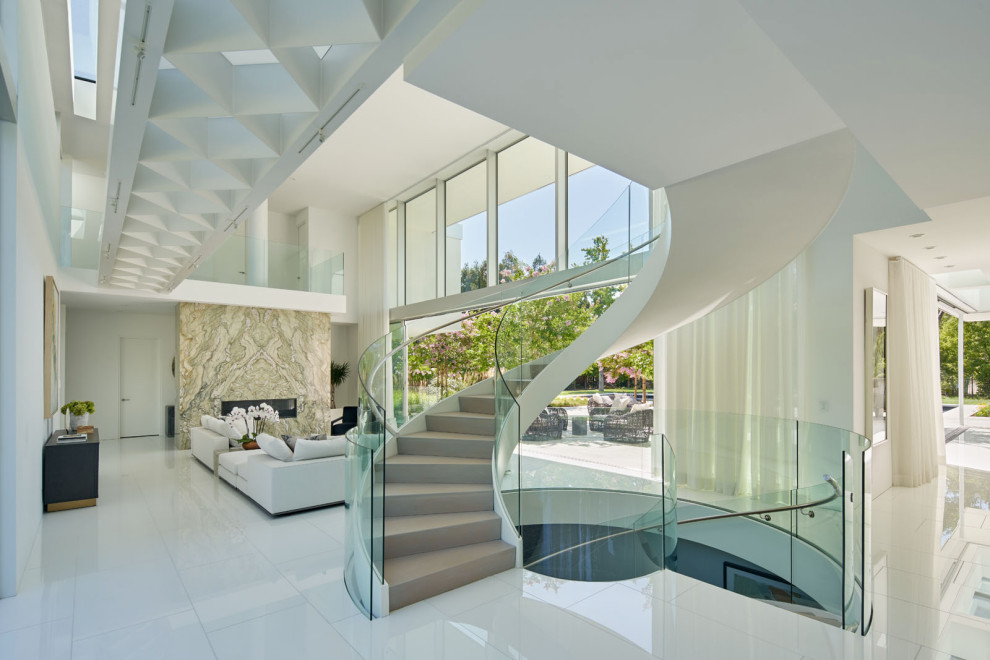 Idées déco pour un grand escalier courbe contemporain avec des marches en bois, des contremarches en bois et un garde-corps en verre.
