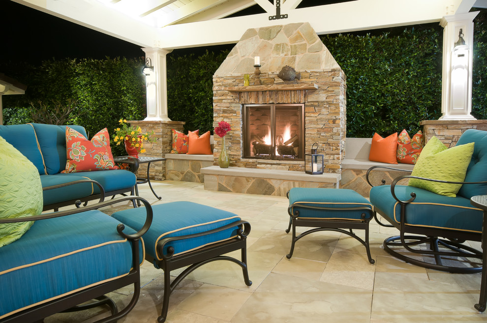 This is an example of a large beach style backyard patio in San Diego with a fire feature, natural stone pavers and a pergola.