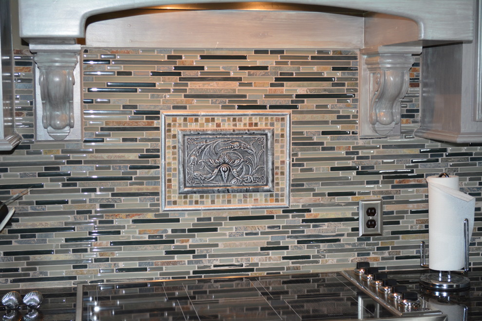 Mid-sized transitional l-shaped enclosed kitchen photo with raised-panel cabinets, distressed cabinets, granite countertops, beige backsplash, matchstick tile backsplash, stainless steel appliances and an island