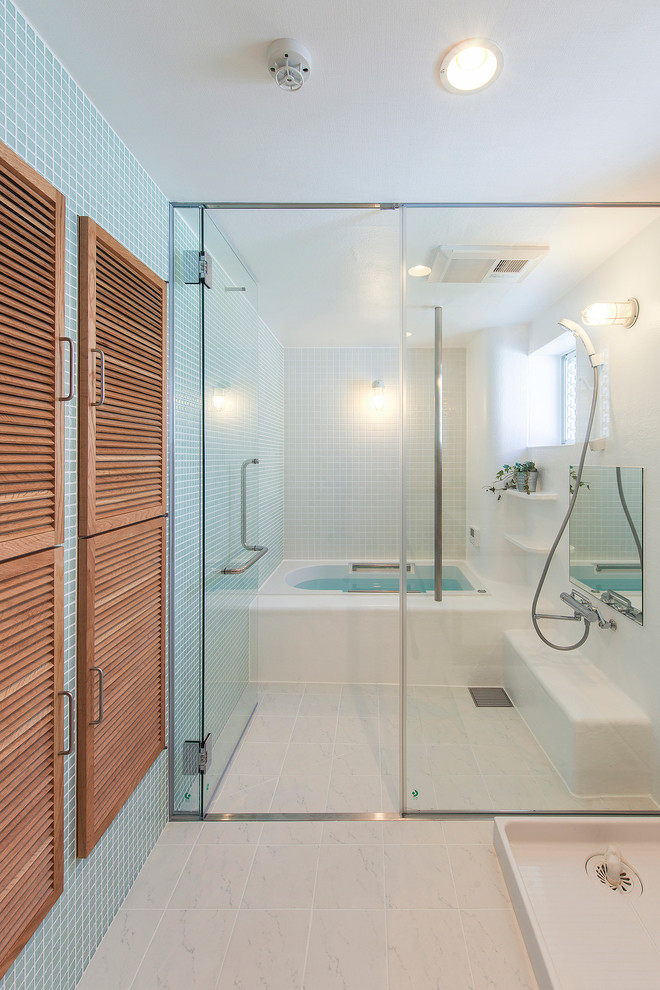 Inspiration for a contemporary bathroom in Osaka with light wood cabinets, an alcove tub, a curbless shower, blue tile and blue walls.