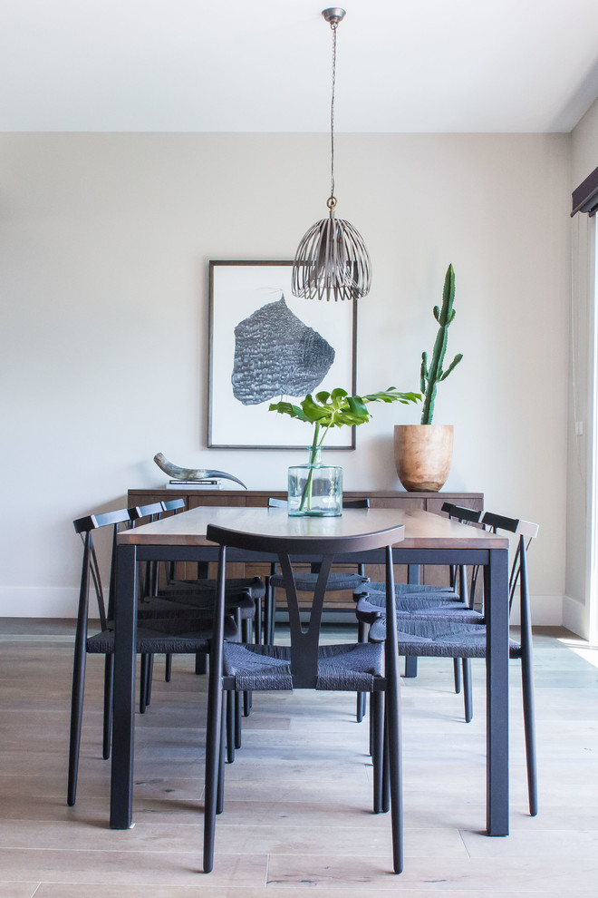 This is an example of a contemporary dining room in Melbourne with beige walls and light hardwood floors.