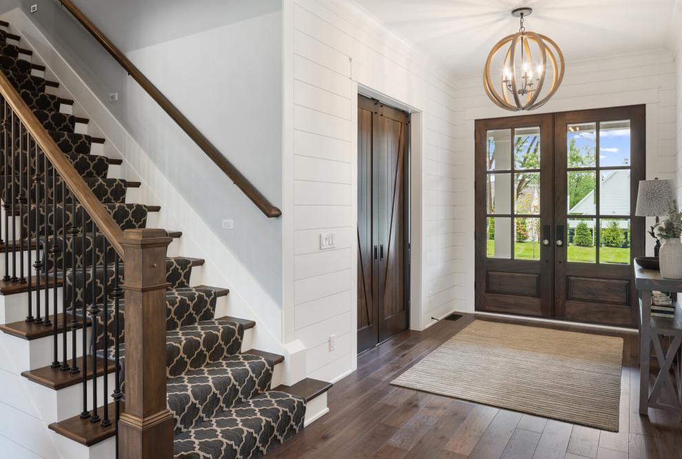 Country entryway in Cincinnati with a double front door, a dark wood front door and planked wall panelling.
