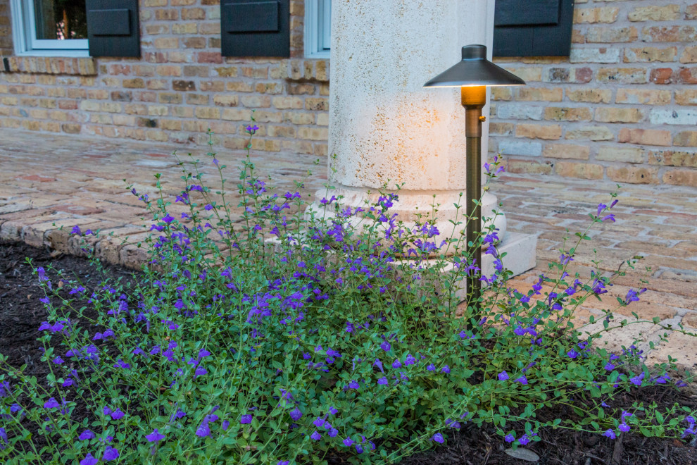 Großer Klassischer Vorgarten im Sommer mit Blumenbeet, direkter Sonneneinstrahlung, Mulch und Metallzaun in Austin