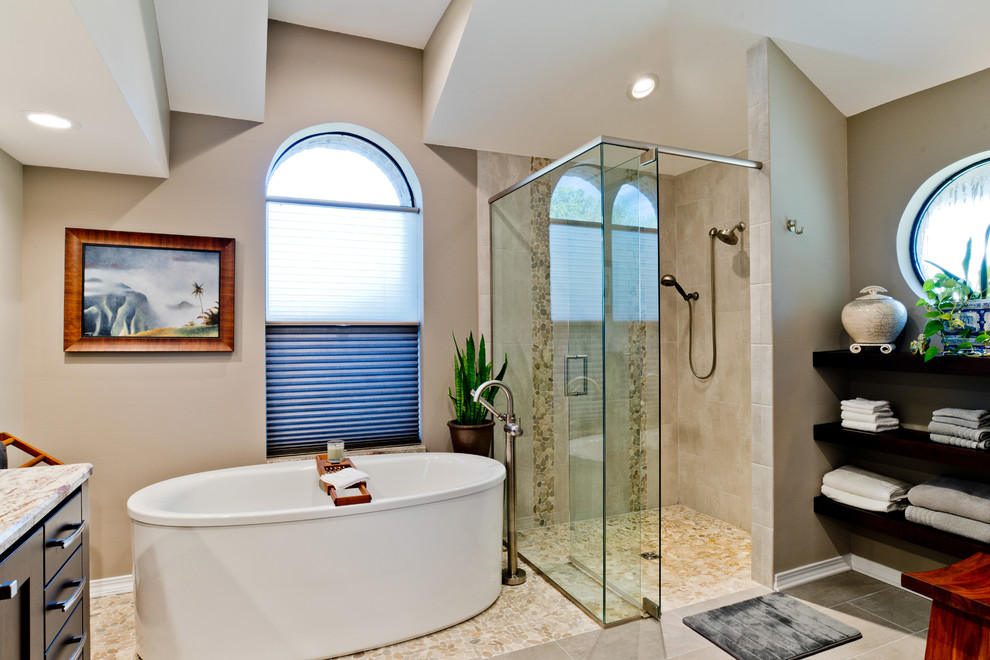 Design ideas for a large asian master bathroom in Miami with shaker cabinets, dark wood cabinets, a freestanding tub, a curbless shower, a two-piece toilet, gray tile, porcelain tile, beige walls, porcelain floors, an undermount sink and granite benchtops.
