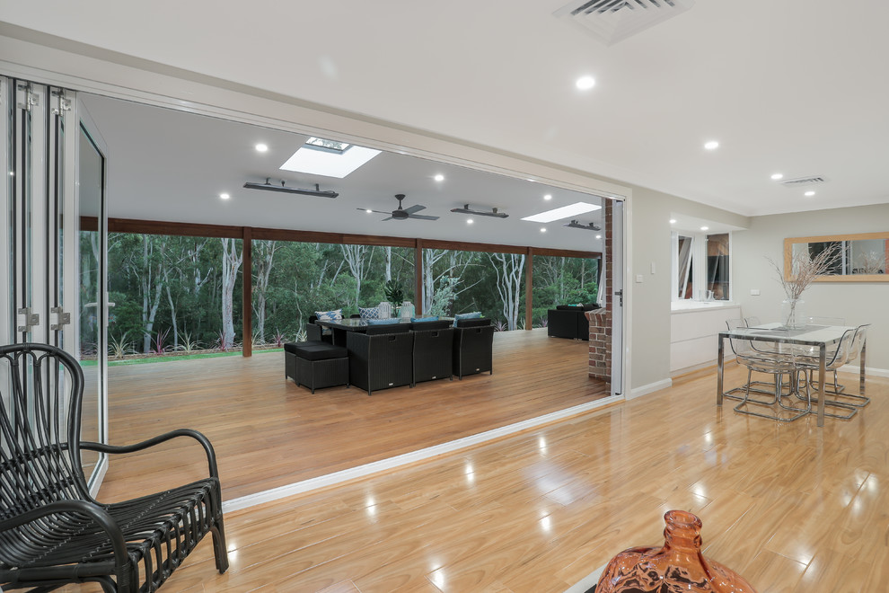 This is an example of an expansive contemporary backyard patio in Sydney with decking and a roof extension.