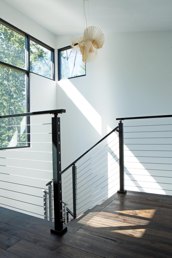 Photo of a mid-sized contemporary wood u-shaped staircase in Other with wood risers and metal railing.