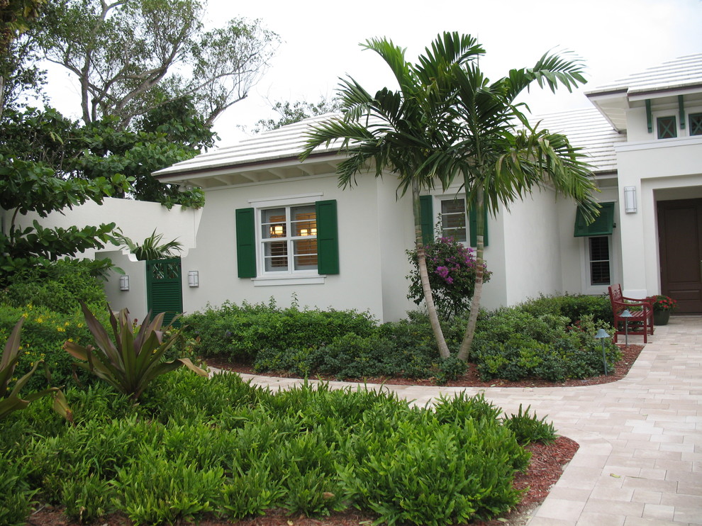 Photo of a large tropical one-storey stucco white exterior in Miami with a gable roof.