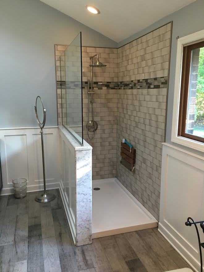 Large transitional master bathroom in Other with shaker cabinets, dark wood cabinets, a freestanding tub, a corner shower, a one-piece toilet, gray tile, porcelain tile, blue walls, painted wood floors, an undermount sink and marble benchtops.