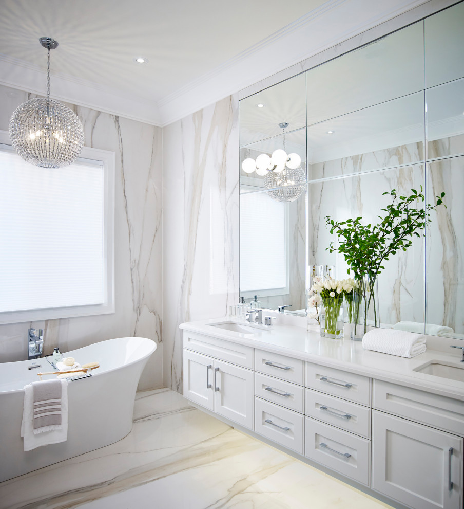 This is an example of a large transitional master bathroom in Toronto with white cabinets, a freestanding tub, beige tile, porcelain tile, beige walls, porcelain floors, an undermount sink, engineered quartz benchtops, beige floor, a hinged shower door, white benchtops, a double vanity, a floating vanity and recessed-panel cabinets.