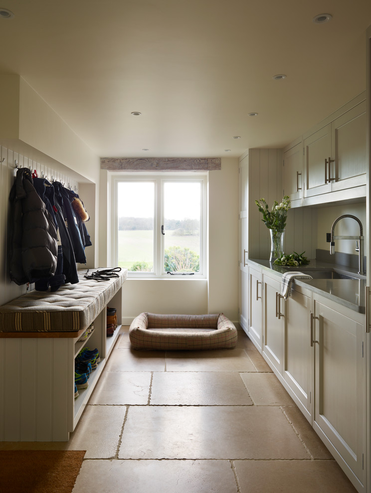 Large transitional laundry room in Berkshire with beige cabinets and solid surface benchtops.