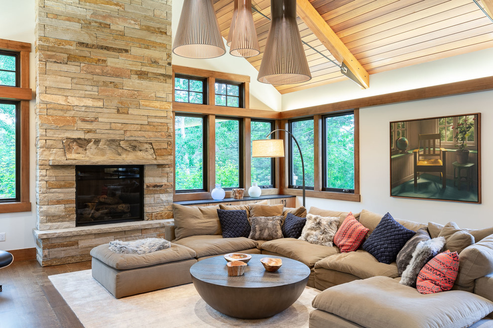 Design ideas for a country family room in Denver with white walls, dark hardwood floors, a standard fireplace, a stone fireplace surround and brown floor.