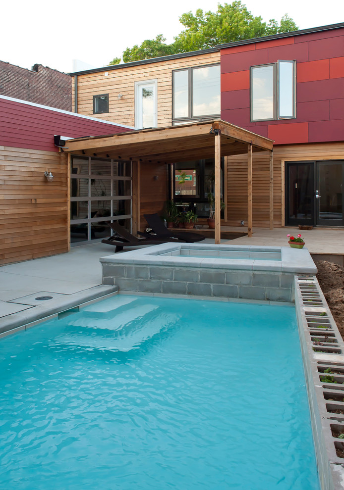 This is an example of a mid-sized contemporary courtyard rectangular pool in St Louis with concrete pavers.