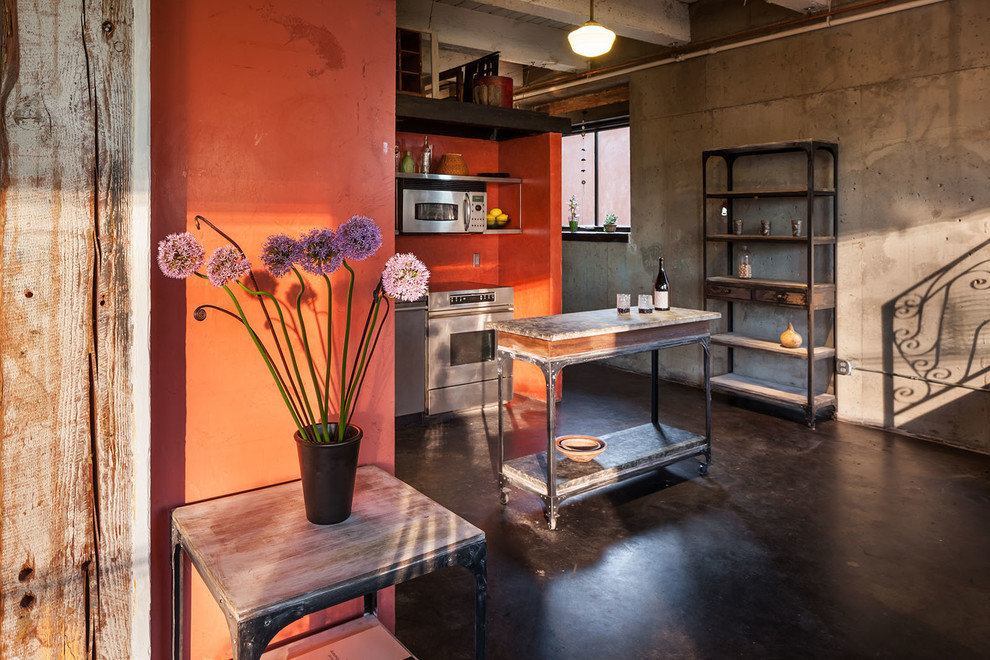Inspiration for an industrial home office in Portland with red walls and concrete floors.