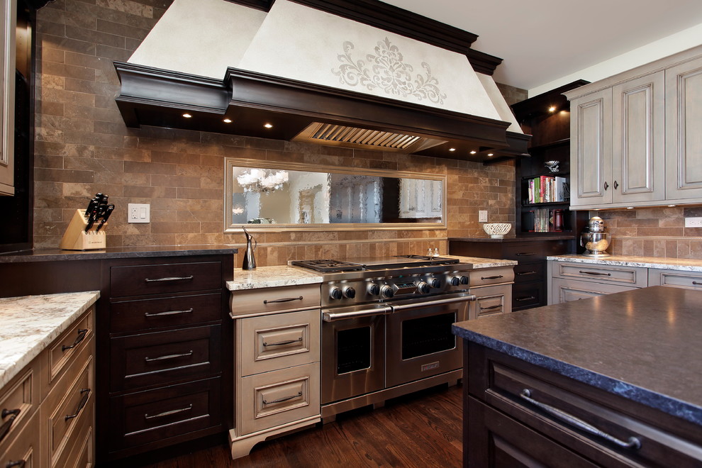 Inspiration for a large transitional u-shaped medium tone wood floor eat-in kitchen remodel in Chicago with raised-panel cabinets, medium tone wood cabinets, granite countertops, brown backsplash, subway tile backsplash, stainless steel appliances and an island