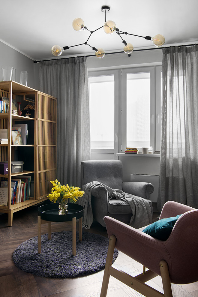 Idée de décoration pour un salon gris et blanc design de taille moyenne avec une bibliothèque ou un coin lecture, un mur gris, sol en stratifié et un sol marron.