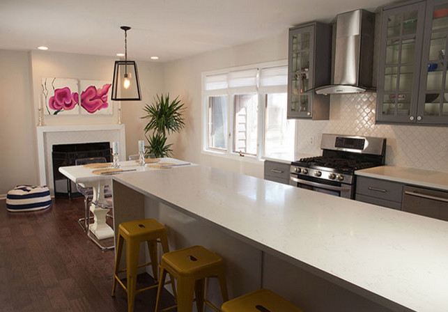 Kitchen - medium tone wood floor kitchen idea with gray cabinets, white backsplash, stainless steel appliances and an island