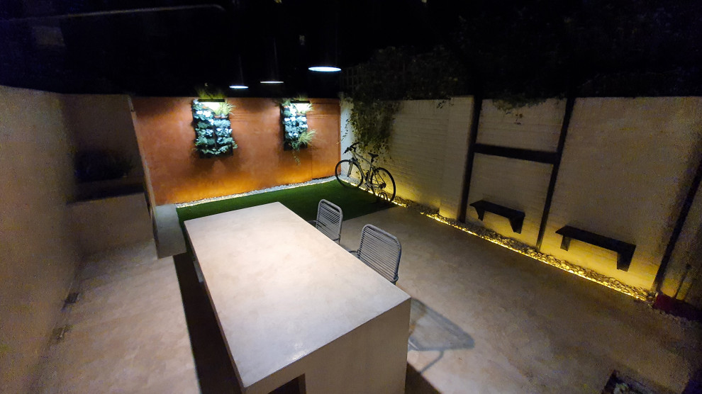 Immagine di un piccolo giardino formale minimalista esposto a mezz'ombra dietro casa in estate con pavimentazioni in cemento