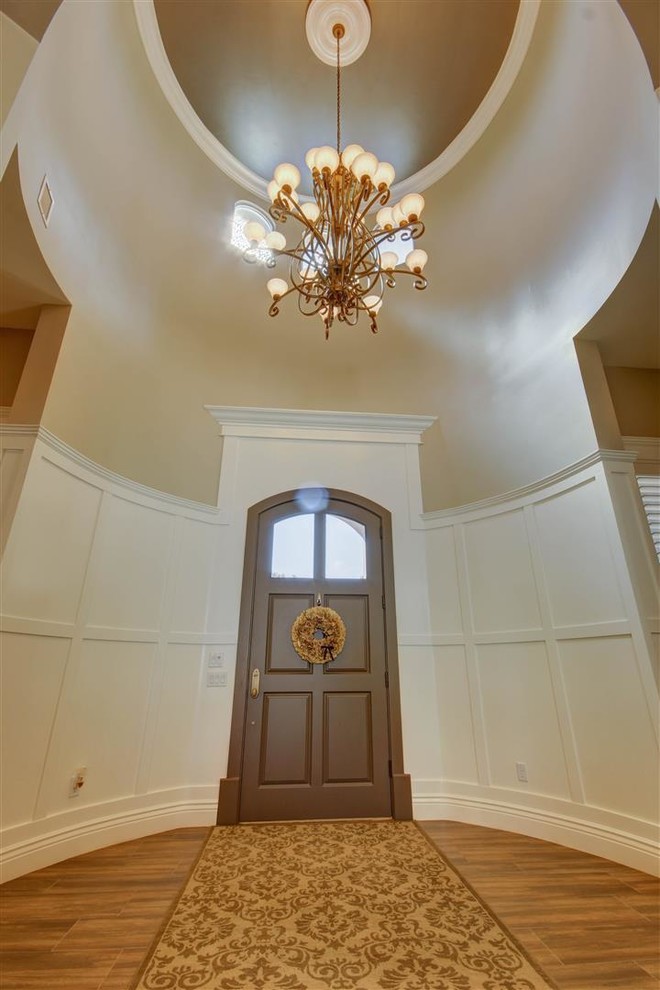 Example of a large transitional medium tone wood floor foyer design in Phoenix with gray walls and a brown front door