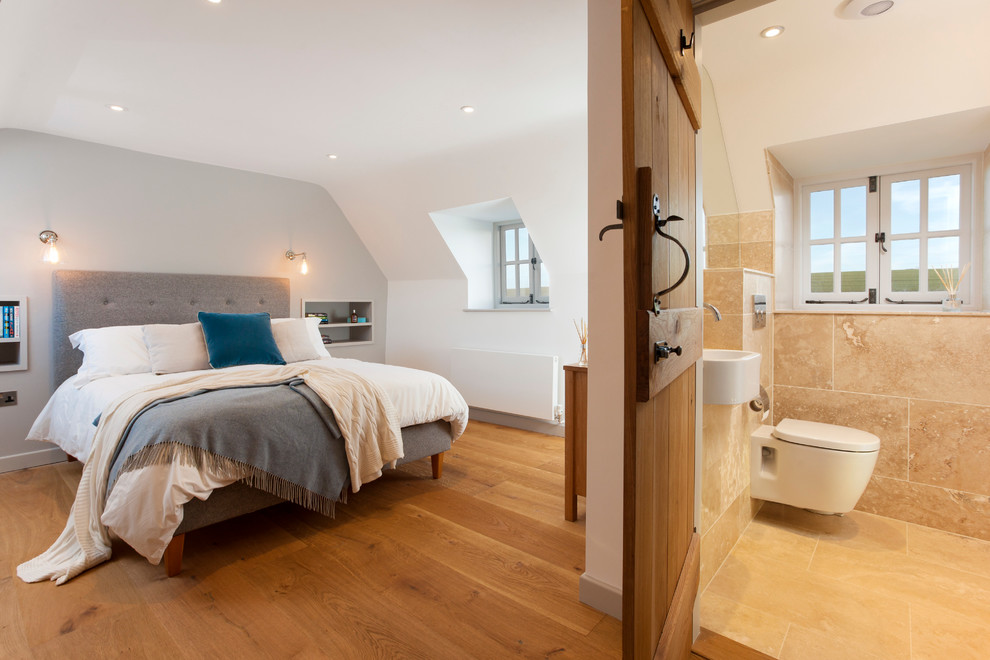 This is an example of a large contemporary master bedroom in Kent with white walls and medium hardwood floors.