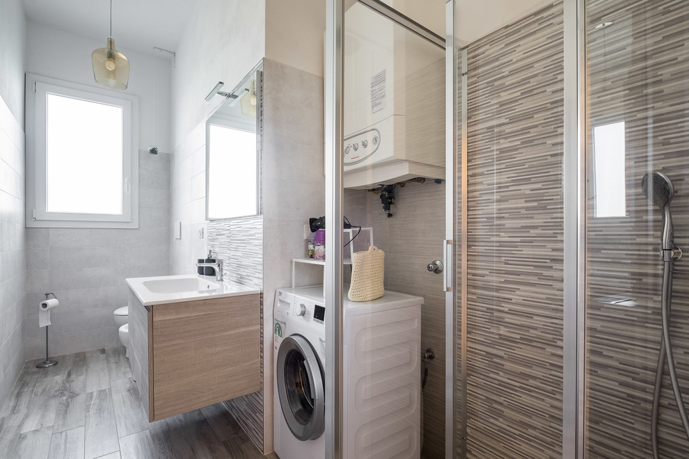 Mid-sized modern 3/4 bathroom in Bologna with flat-panel cabinets, light wood cabinets, a corner shower, a wall-mount toilet, brown tile, porcelain tile, white walls, porcelain floors, a drop-in sink, solid surface benchtops, brown floor, a hinged shower door and white benchtops.