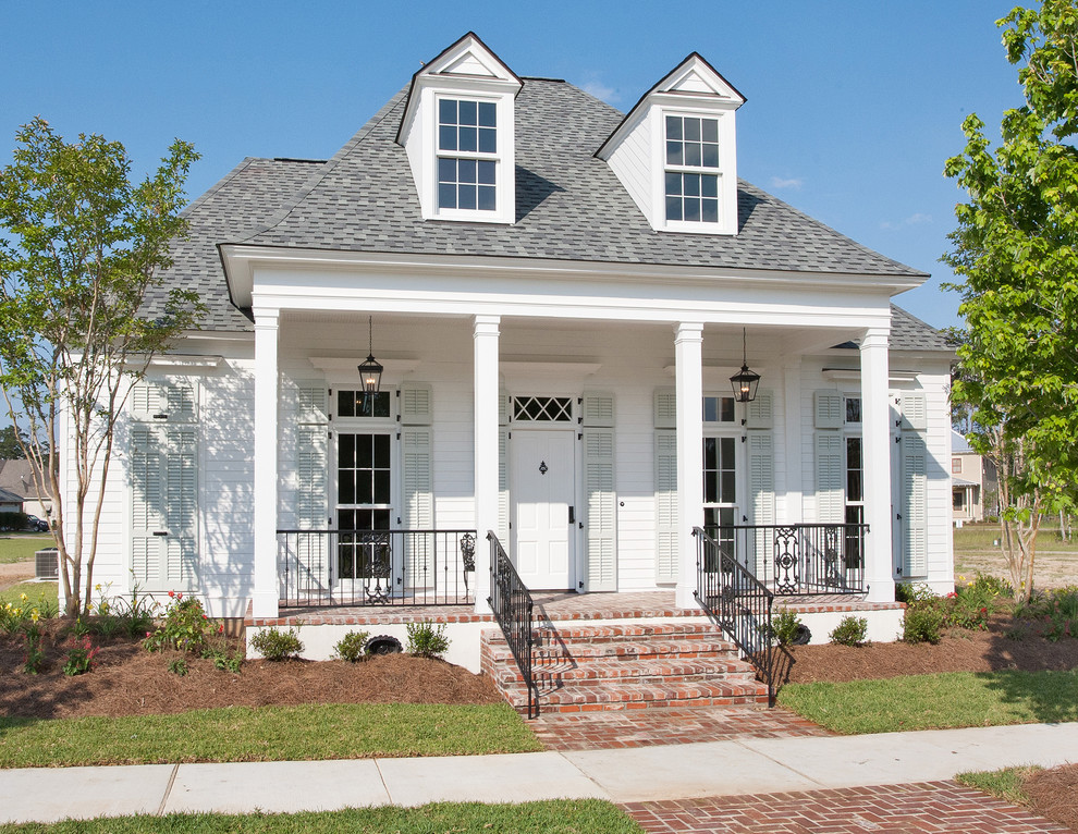 Design ideas for a small traditional two-storey white exterior in New Orleans with wood siding and a hip roof.
