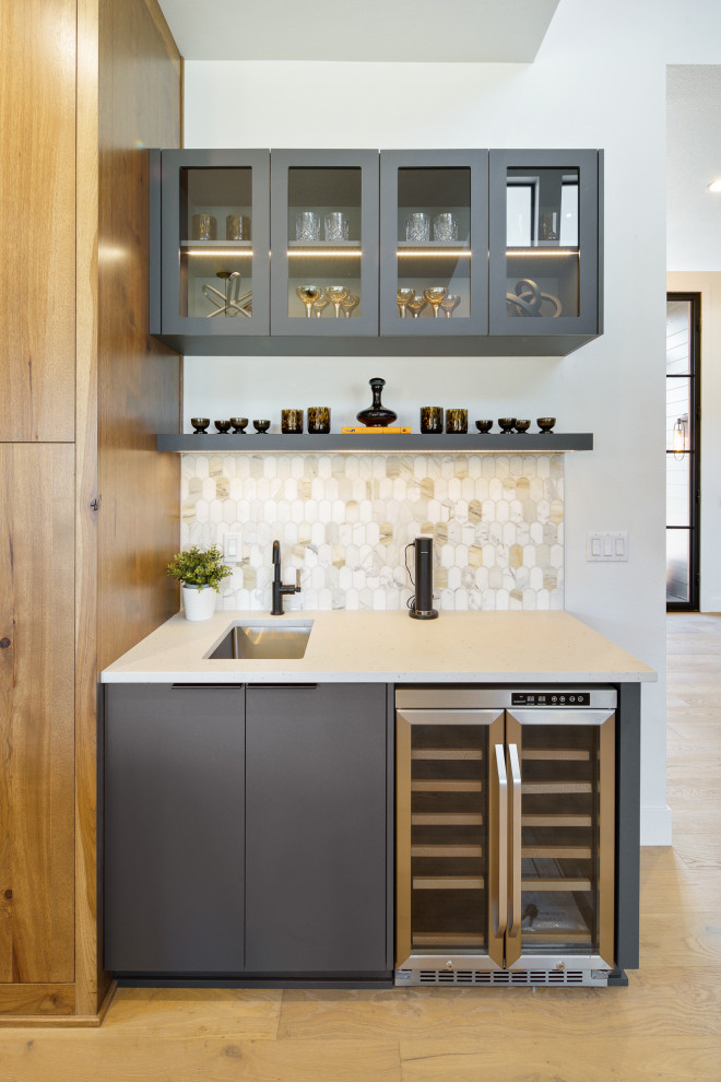Inspiration for a large contemporary single-wall home bar in Portland with a built-in sink, flat-panel cabinets, medium wood cabinets, granite worktops, beige splashback, medium hardwood flooring, brown floors and beige worktops.