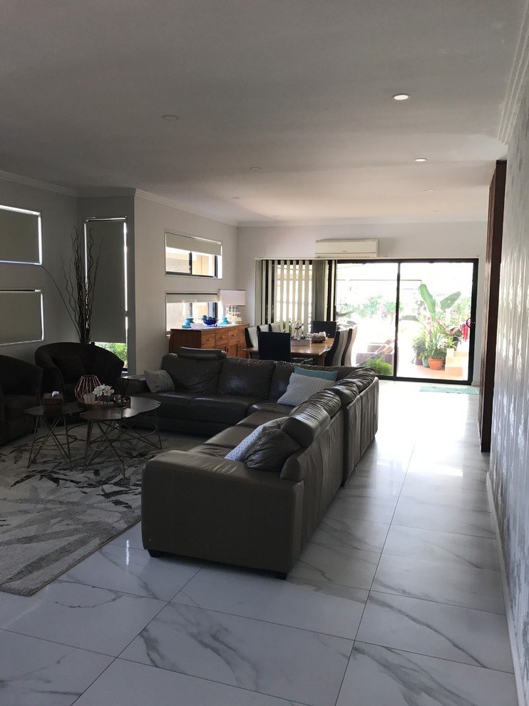 Photo of a mid-sized contemporary open concept living room in Sydney with white walls, marble floors, a wall-mounted tv and white floor.