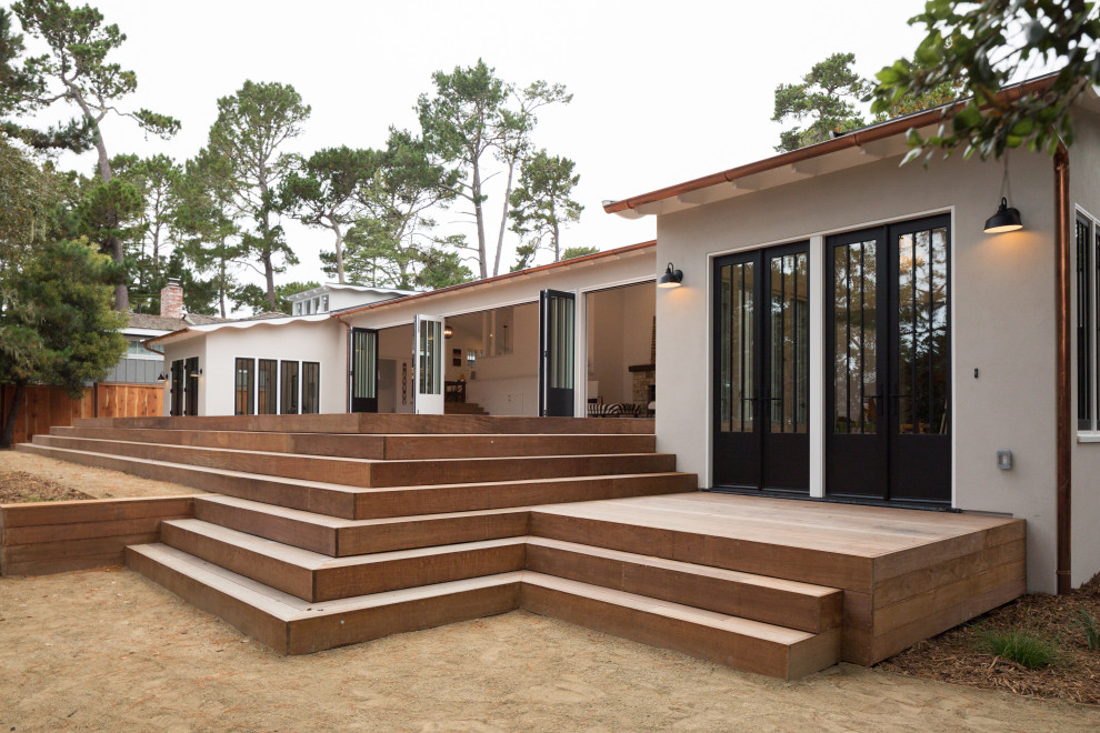 Example of a large transitional beige split-level stucco house exterior design with a hip roof and a shingle roof