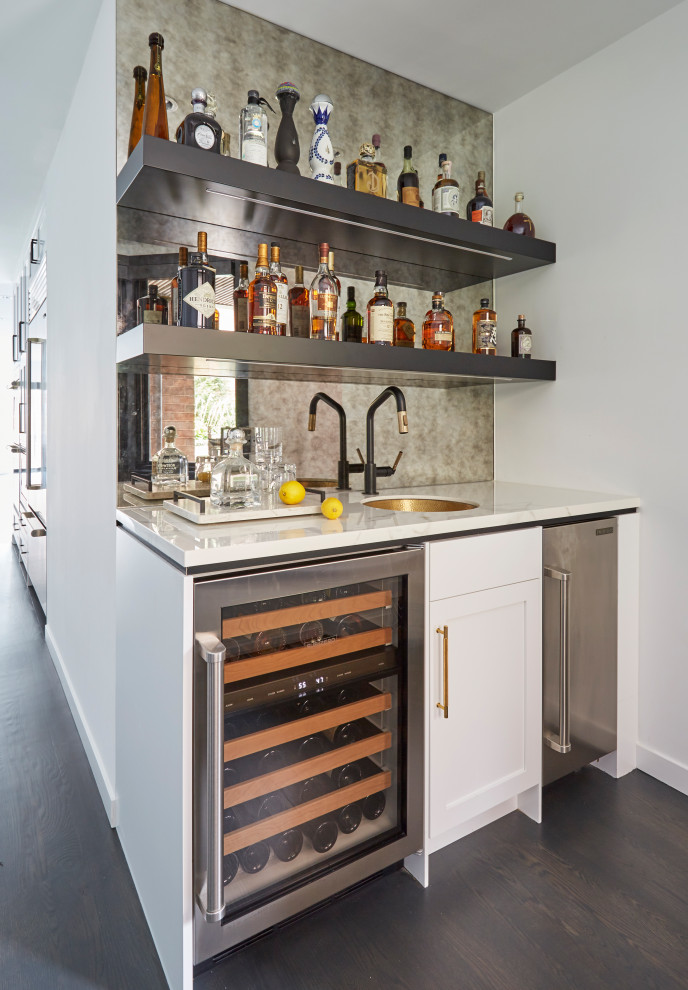 Contemporary single-wall wet bar in Chicago with an undermount sink, shaker cabinets, white cabinets, mirror splashback, dark hardwood floors, brown floor and white benchtop.