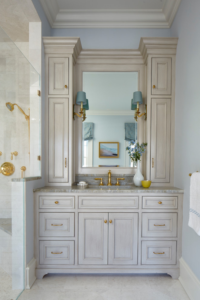 Inspiration for a traditional master bathroom in New York with recessed-panel cabinets, grey cabinets, a freestanding tub, a corner shower, gray tile, mosaic tile, blue walls, marble floors, an undermount sink, tile benchtops, grey floor, a hinged shower door and grey benchtops.