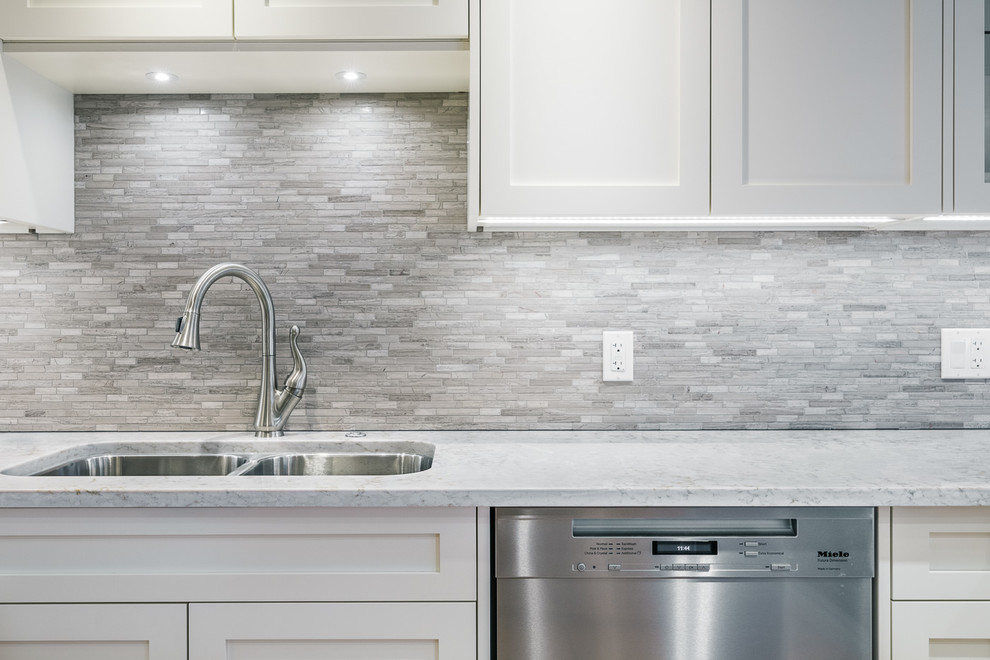 Large trendy u-shaped medium tone wood floor eat-in kitchen photo in Calgary with an undermount sink, shaker cabinets, white cabinets, marble countertops, gray backsplash, matchstick tile backsplash, stainless steel appliances and a peninsula