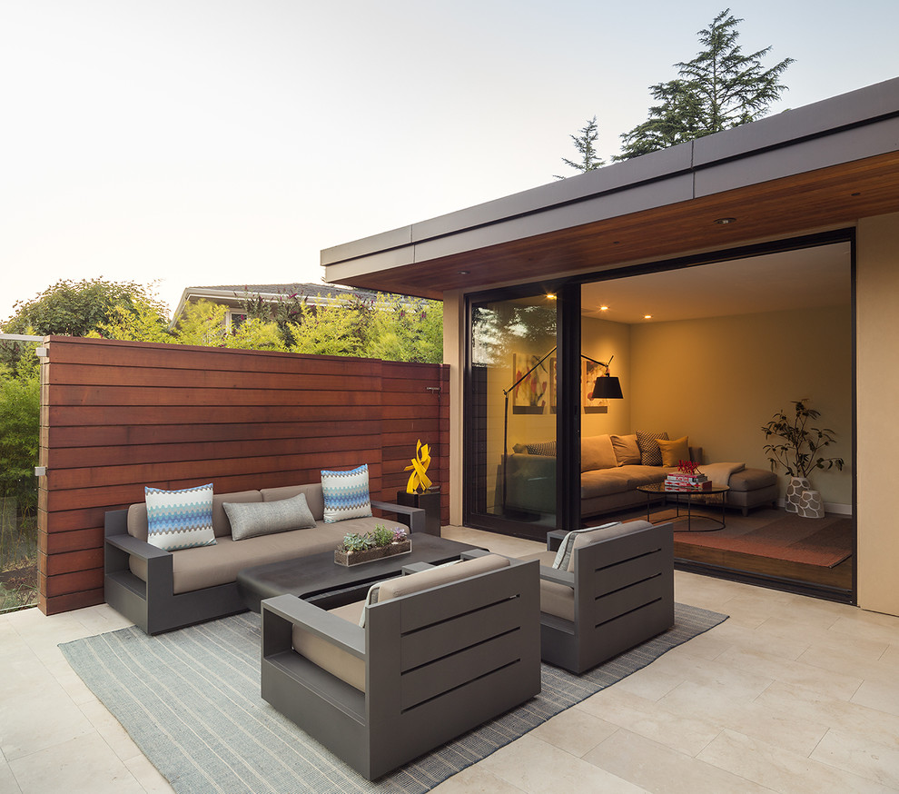 This is an example of an expansive midcentury side yard patio in San Francisco with tile and no cover.