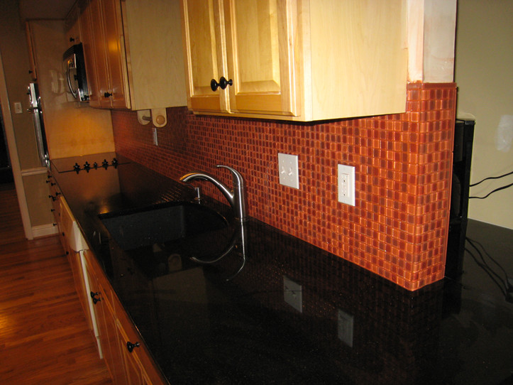 Kitchen - transitional medium tone wood floor kitchen idea in St Louis with an undermount sink, light wood cabinets, red backsplash, mosaic tile backsplash and stainless steel appliances