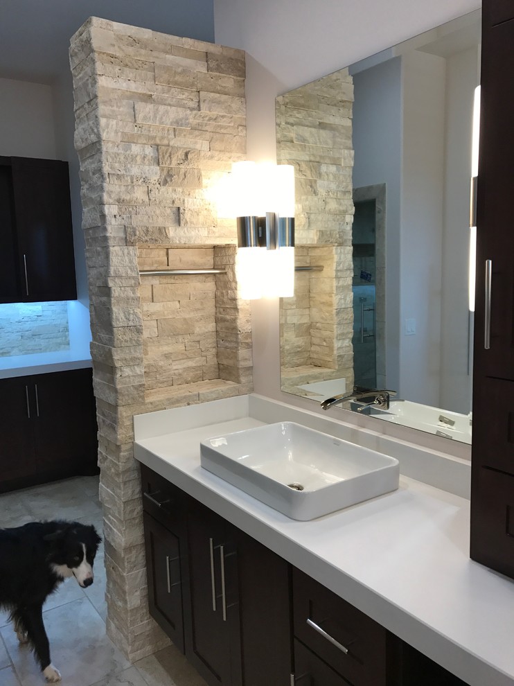 This is an example of a large modern master bathroom in Oklahoma City with shaker cabinets, dark wood cabinets, a freestanding tub, beige tile, stone tile, a drop-in sink, engineered quartz benchtops, beige floor, an open shower, a one-piece toilet, white walls, porcelain floors and an open shower.