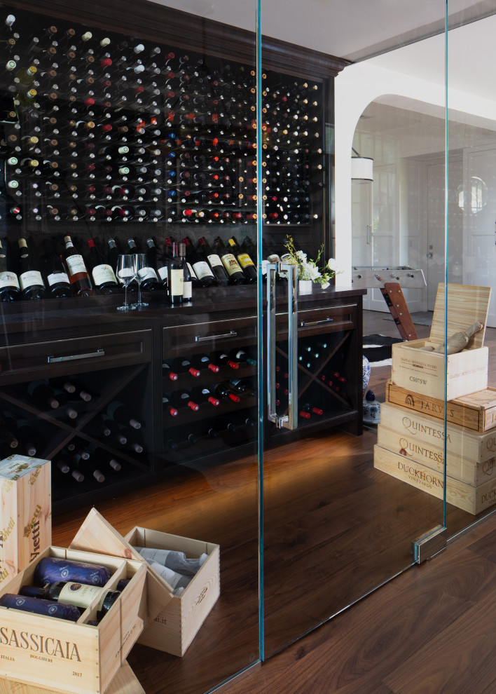 Design ideas for a mid-sized transitional wine cellar in Detroit with medium hardwood floors, display racks and brown floor.