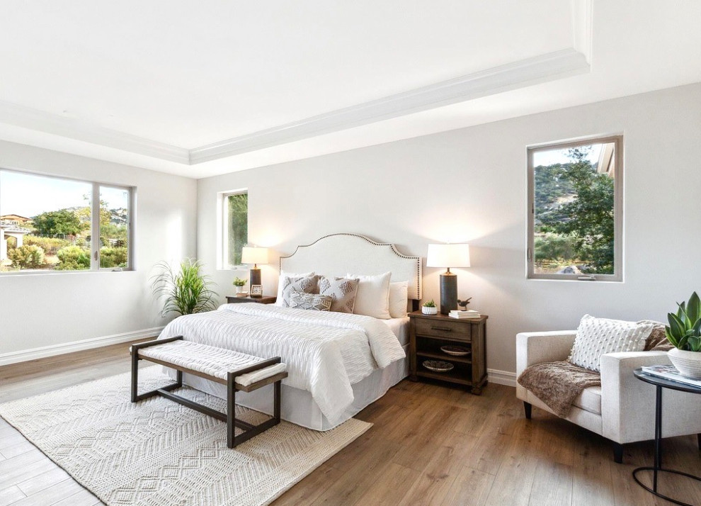 Ispirazione per un'ampia camera matrimoniale minimal con pareti bianche, pavimento in legno massello medio e pavimento marrone