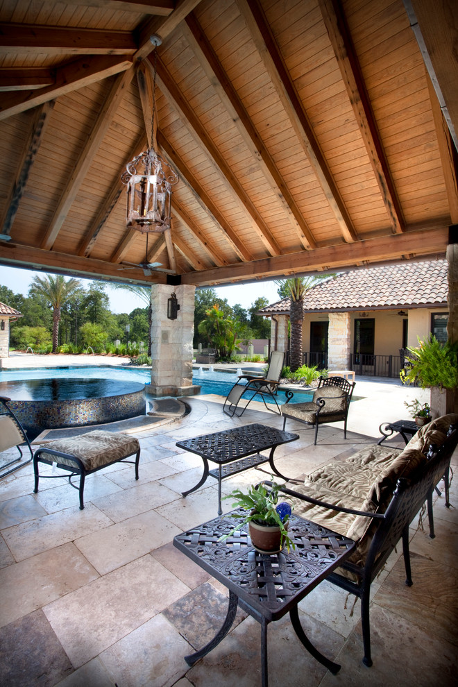 Inspiration for a large mediterranean backyard custom-shaped lap pool in New Orleans with a hot tub and concrete pavers.