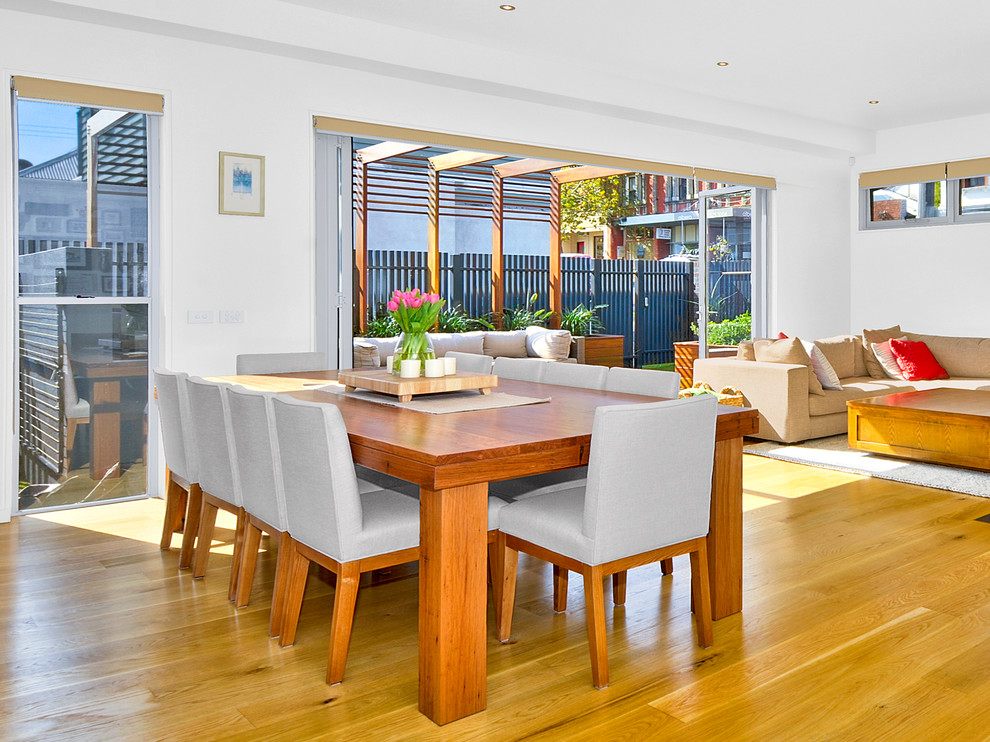 Design ideas for a contemporary dining room in Melbourne with white walls and medium hardwood floors.
