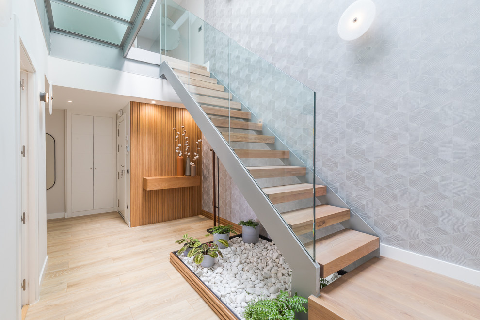 Design ideas for a mid-sized contemporary staircase in Madrid with wallpaper.
