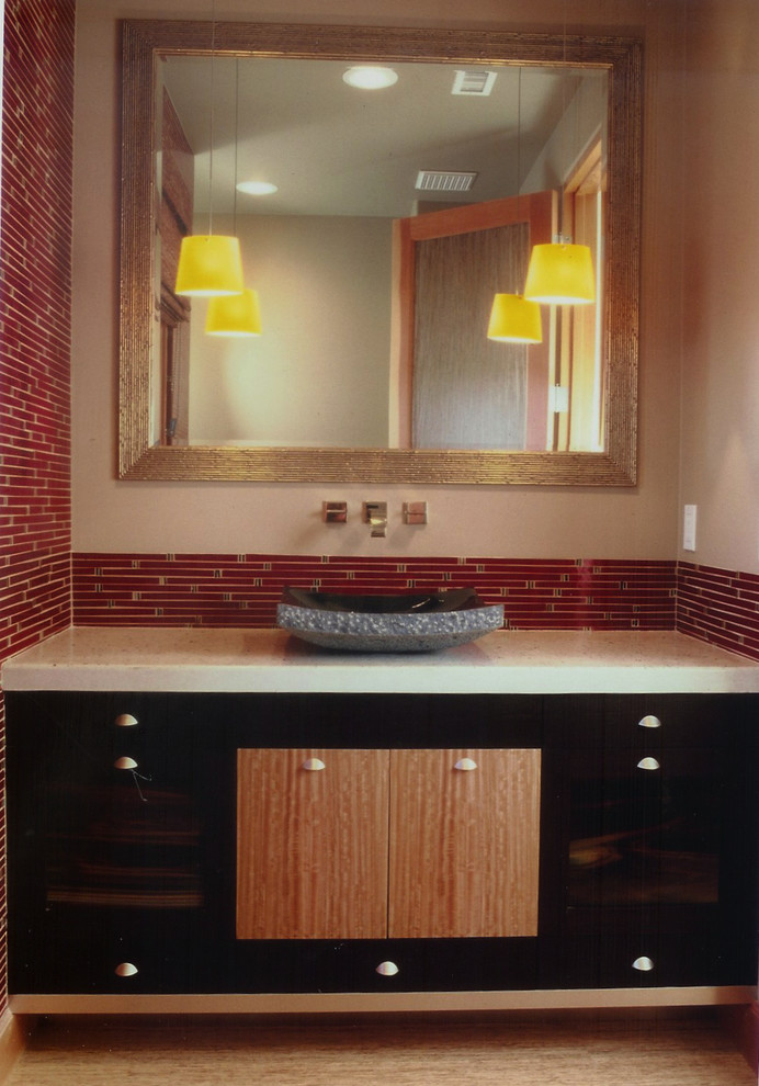 Photo of a mid-sized asian powder room in San Diego with a vessel sink, flat-panel cabinets, dark wood cabinets, a one-piece toilet, red tile, beige walls, bamboo floors and matchstick tile.
