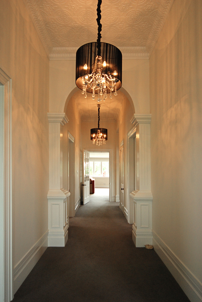 This is an example of a mid-sized contemporary foyer in Auckland with carpet and white walls.