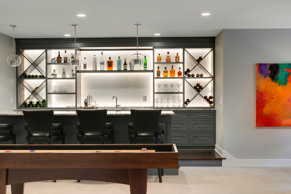 This is an example of a large transitional single-wall wet bar in Minneapolis with an undermount sink, recessed-panel cabinets, grey cabinets, granite benchtops, white splashback and carpet.