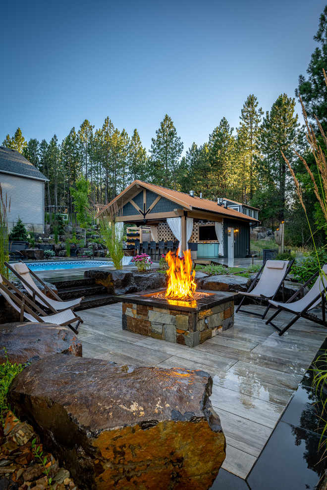 Design ideas for an expansive arts and crafts backyard patio in Seattle with a fire feature, natural stone pavers and a gazebo/cabana.
