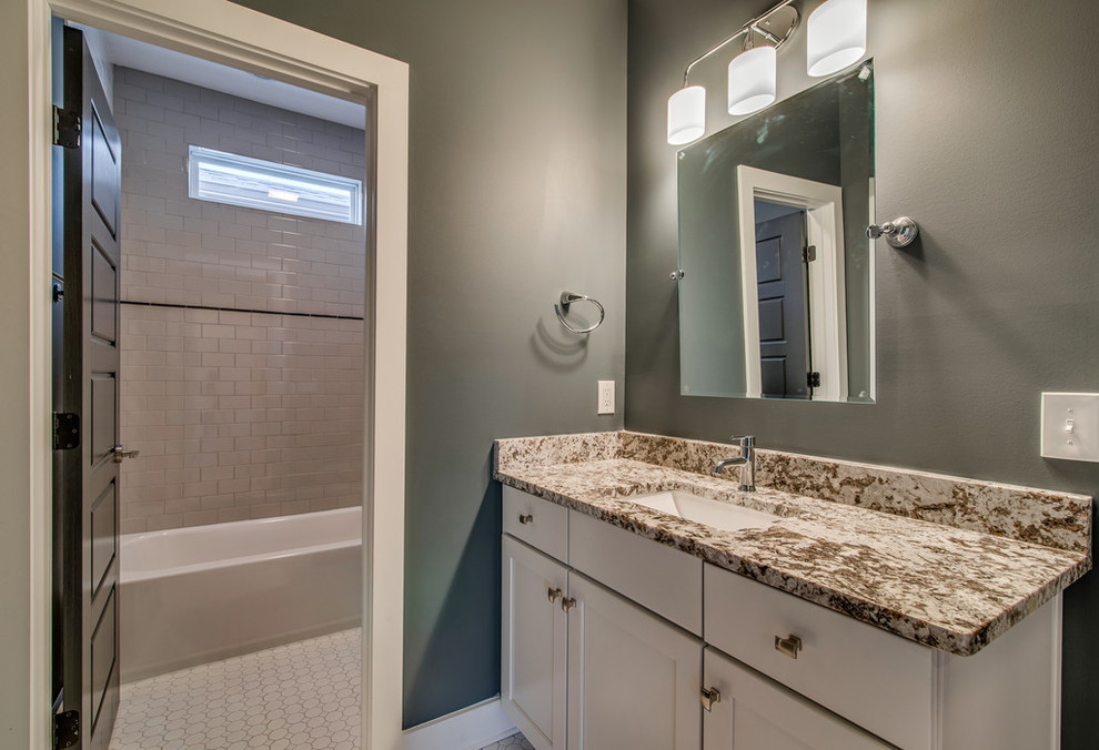 Design ideas for a large transitional 3/4 bathroom in Nashville with shaker cabinets, white cabinets, granite benchtops, an alcove tub, a shower/bathtub combo, white tile and grey walls.