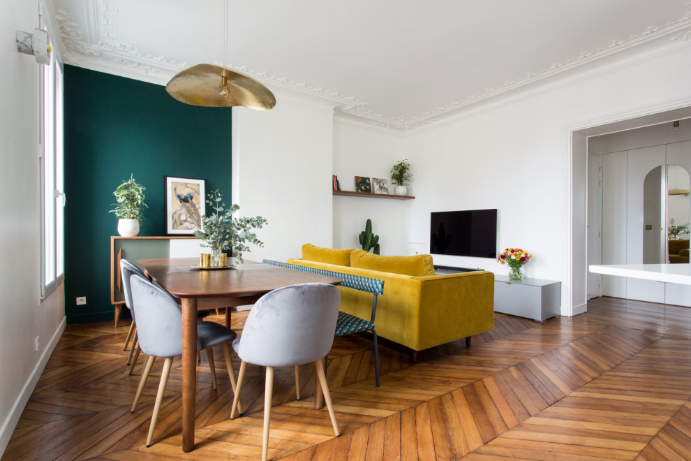 This is an example of a mid-sized contemporary open concept living room in Paris with white walls, medium hardwood floors, a wall-mounted tv and brown floor.