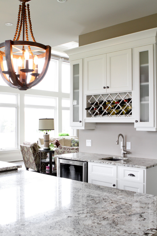 Example of a large transitional u-shaped open concept kitchen design in Toronto with an undermount sink, shaker cabinets, white cabinets, granite countertops, stainless steel appliances and an island
