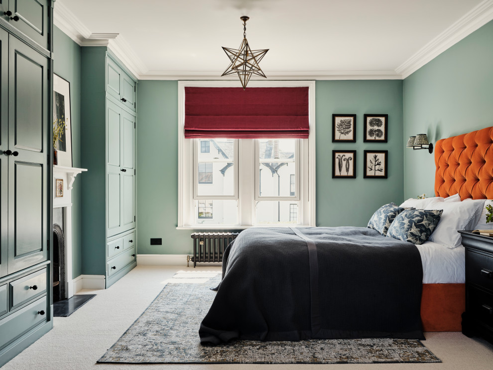 На фото: большая хозяйская спальня: освещение в стиле неоклассика (современная классика) с синими стенами, ковровым покрытием, стандартным камином, фасадом камина из дерева и бежевым полом с