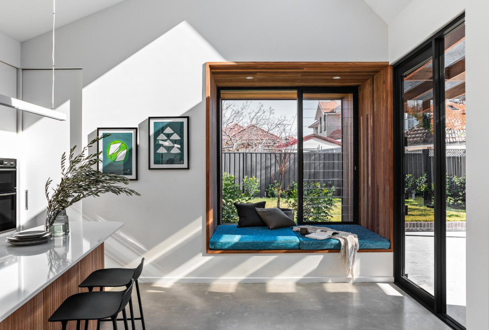 Mittelgroße Moderne Wohnküche ohne Kamin mit weißer Wandfarbe, Betonboden, grauem Boden und gewölbter Decke in Sydney