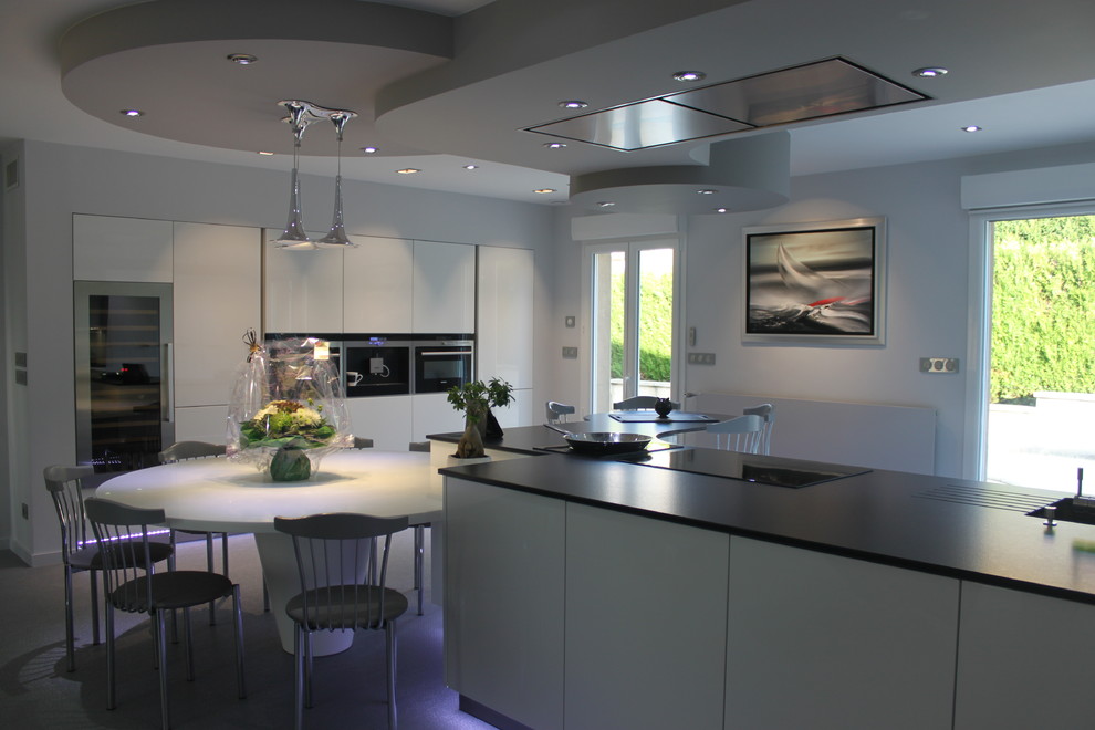 Design ideas for a large modern l-shaped open plan kitchen in Nancy with a single-bowl sink, light wood cabinets, granite benchtops, white splashback, stainless steel appliances and with island.