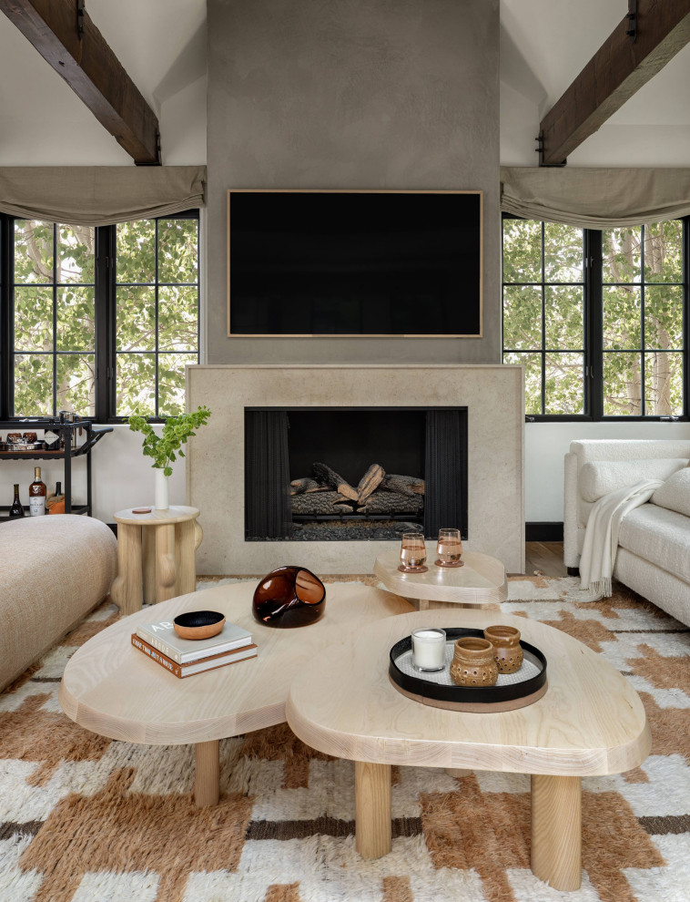 Design ideas for a mid-sized modern enclosed living room in Denver with medium hardwood floors, a standard fireplace, a metal fireplace surround, a wall-mounted tv, white walls, brown floor and exposed beam.